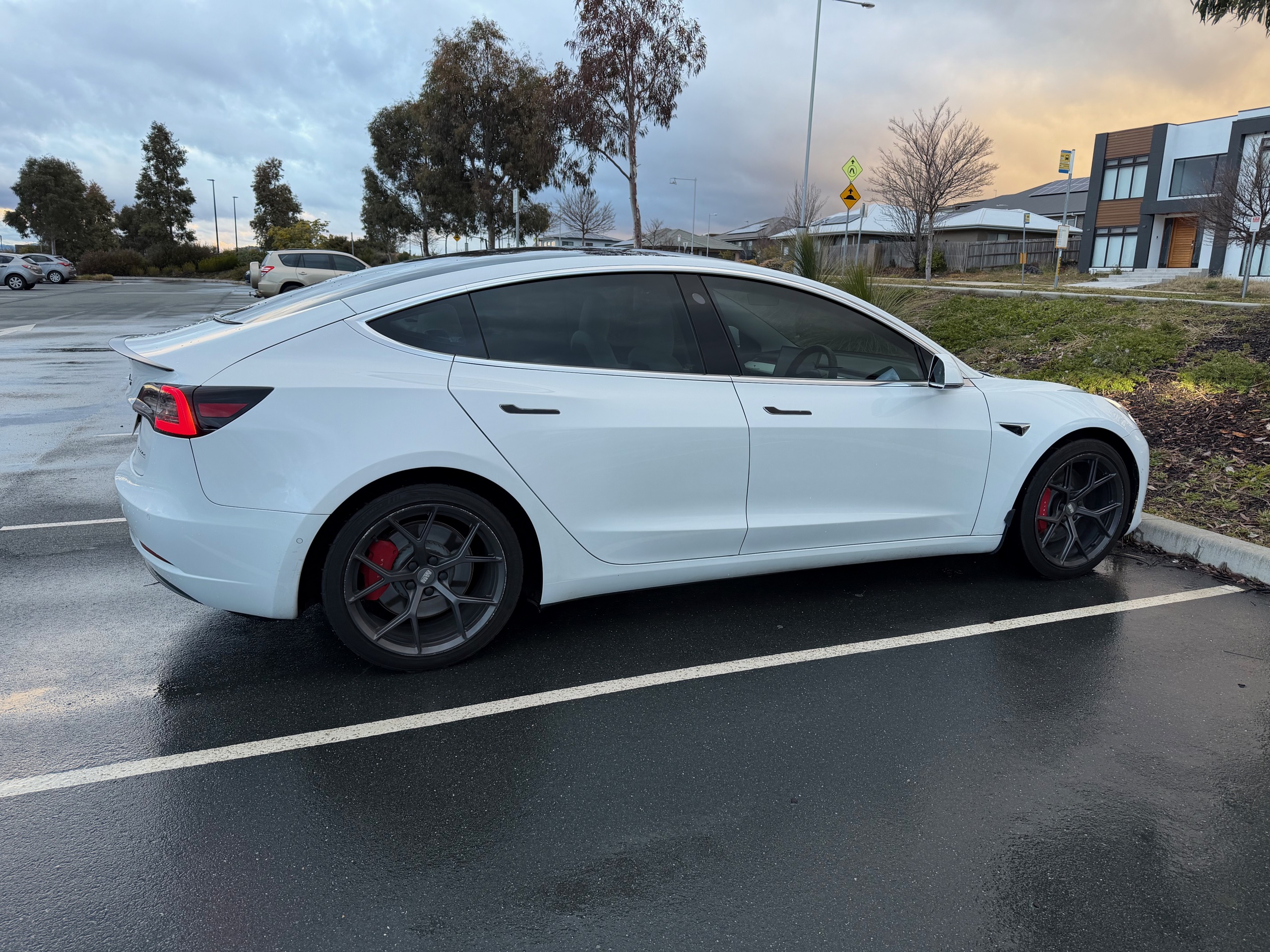 White Tesla Model 3 Performance beneath a stormy Canberra sky